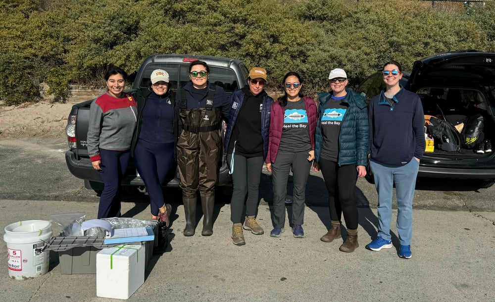 group poses in the parking lot before taking water samples