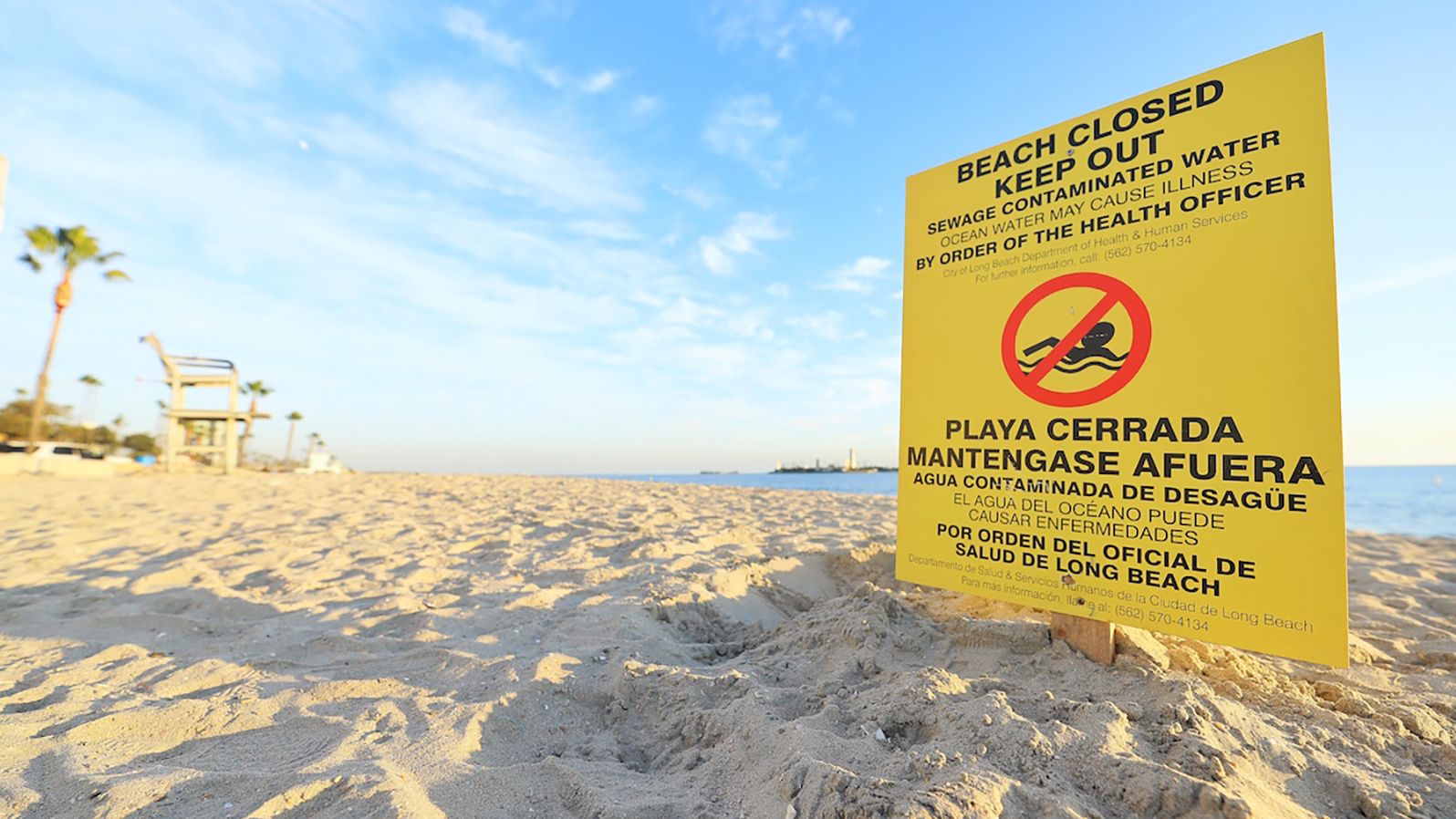 Yellow sign in the sand in Long Beach with the words 