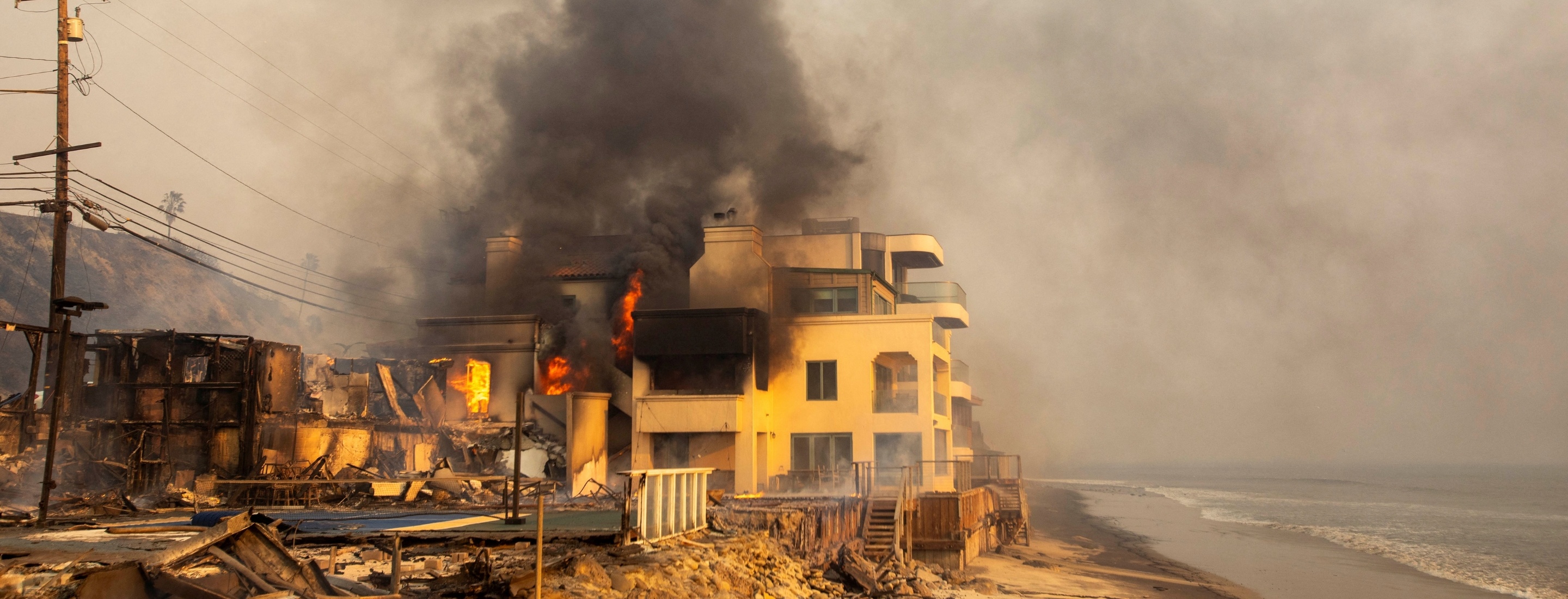 House burns along the water's edge.