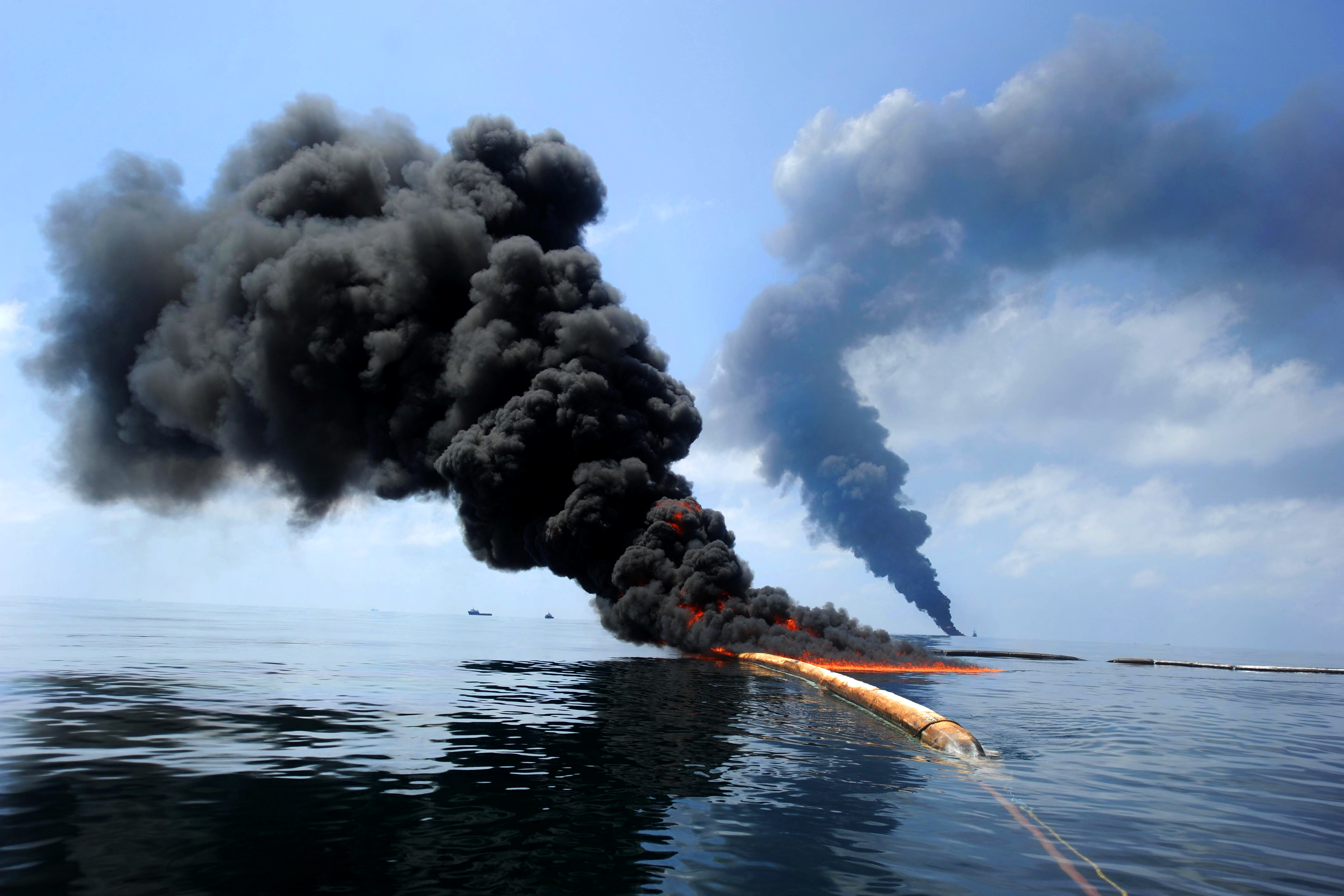 Image shows plumes of smoke rising from the ocean - a result of an off shore drilling accident.